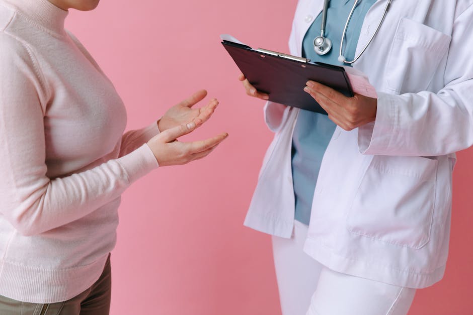 Close-up of a patient consulting a doctor with a clipboard in a medical setting
